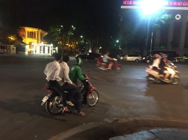 Two yuppies grab a scooter taxi on a night out